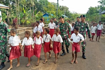 Anggota TNI Pamtas RI-PNG Antarkan Siswa Pergi ke Sekolah   